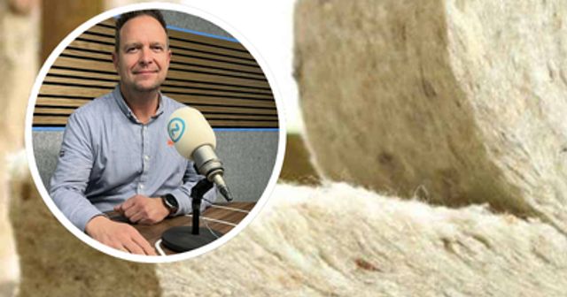 Opgerolde matten natuurlijk isolatiemateriaal, met daaroverheen een ronde foto van Theo van der Sluijs achter een radiomicrofoon