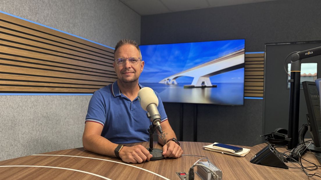 Theo van der Sluijs zit achter de microfoon in de radiostudio van Omroep Zeeland